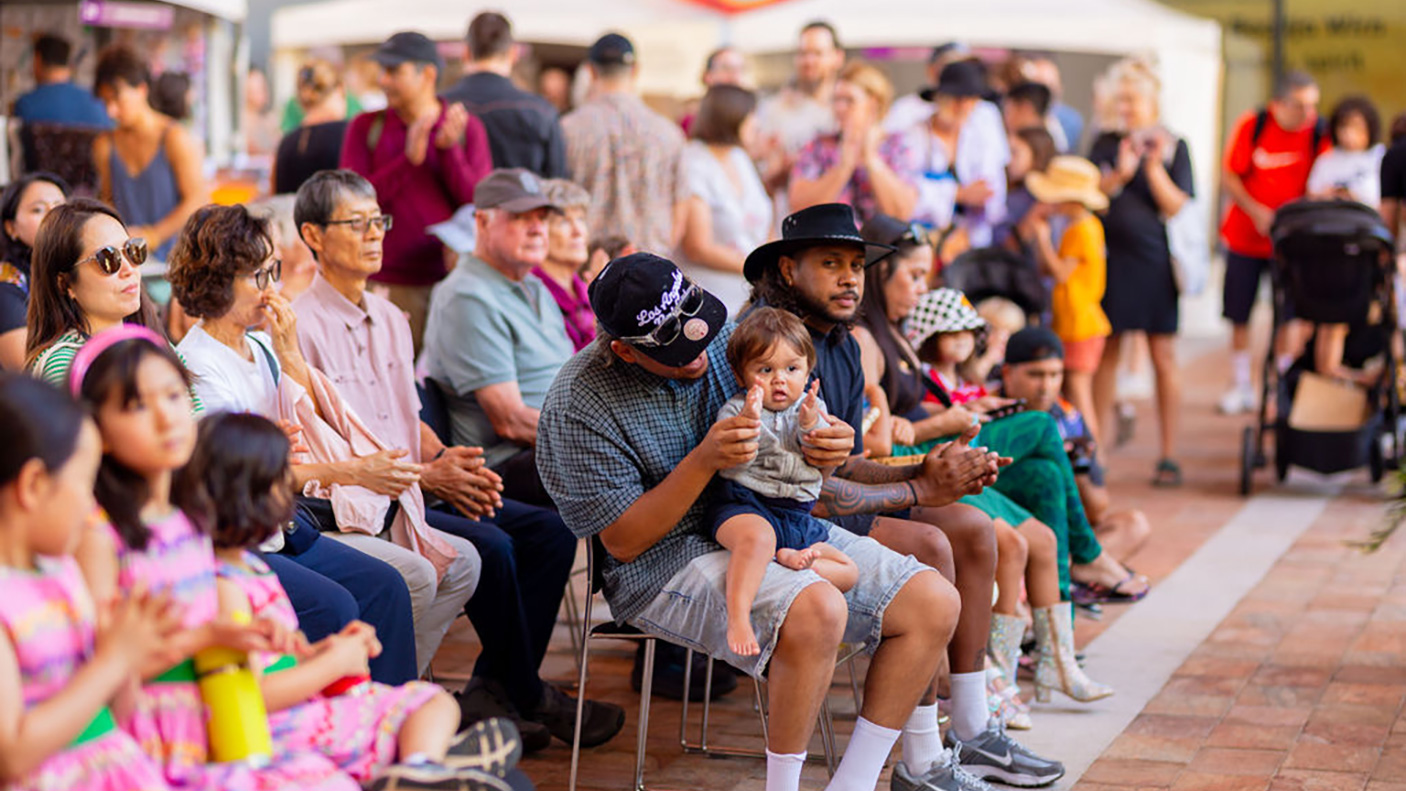 a crowd seated on chairs and standing at an event