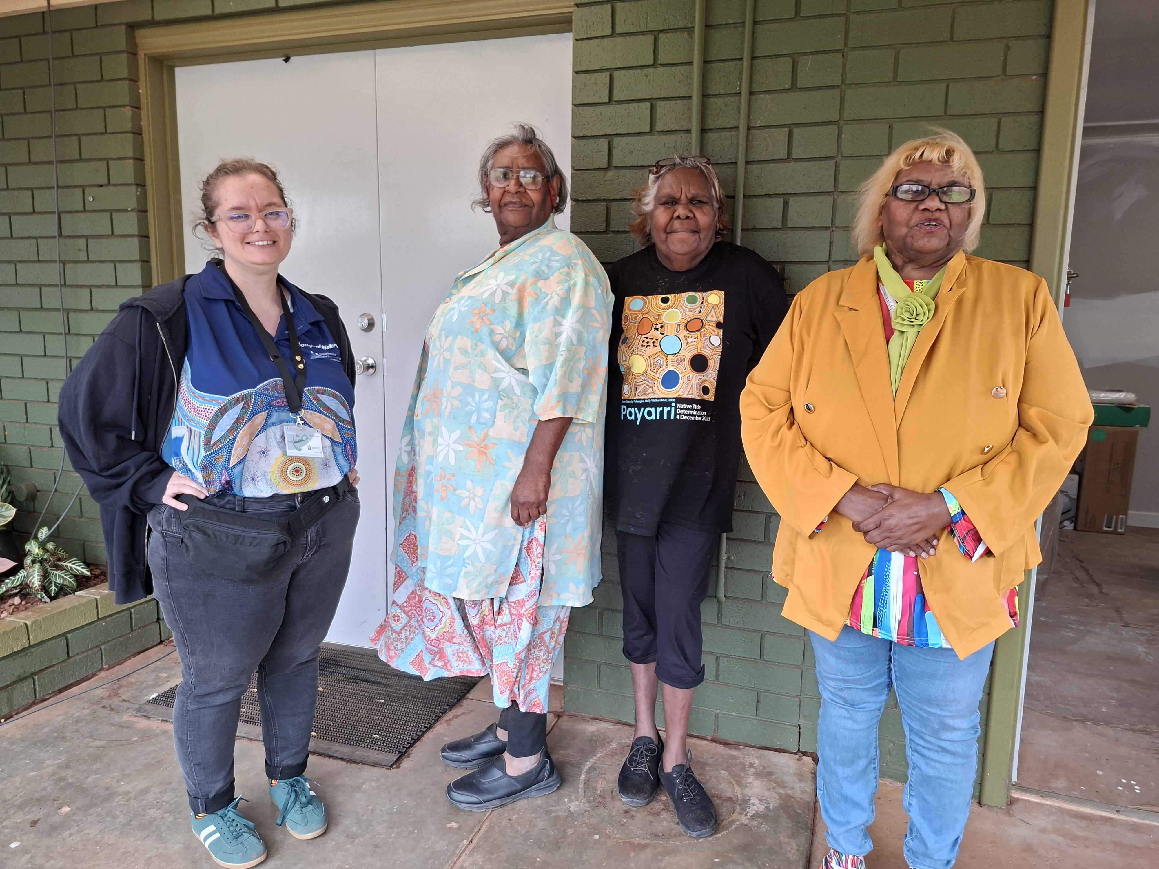 4 people stand outside a building