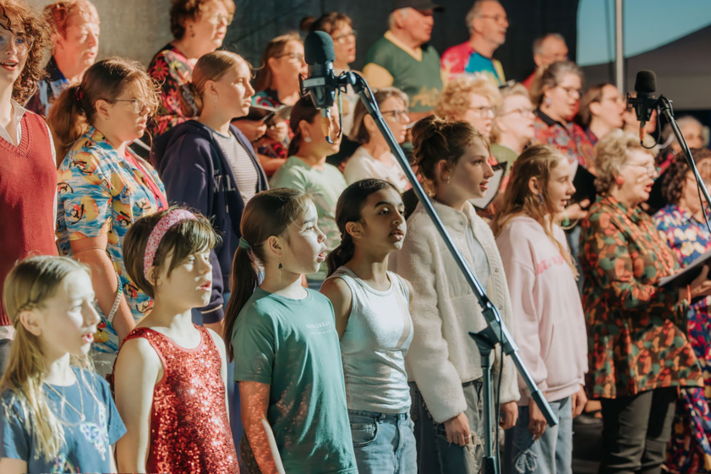 A large group of people sing in a choir