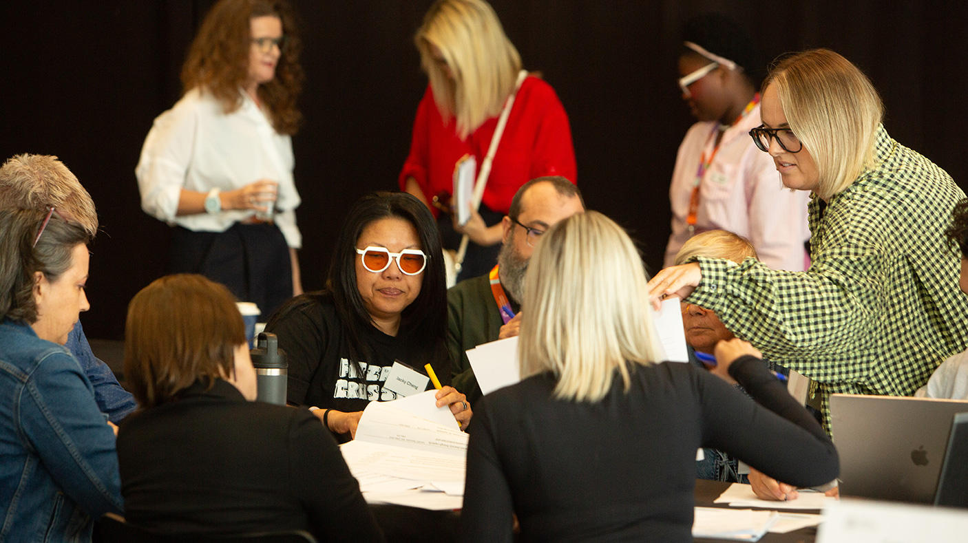A group of people engaged in a discussion, sit and stand at a meeting d