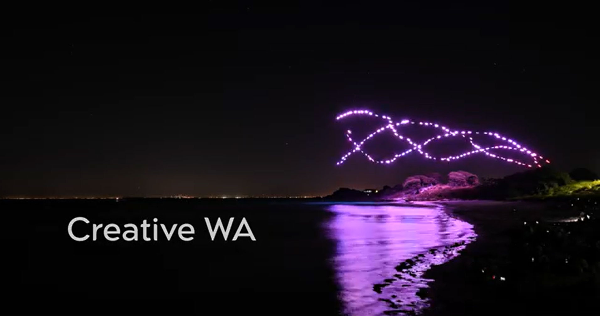 A night scene with purple coloured drone hovering over a river