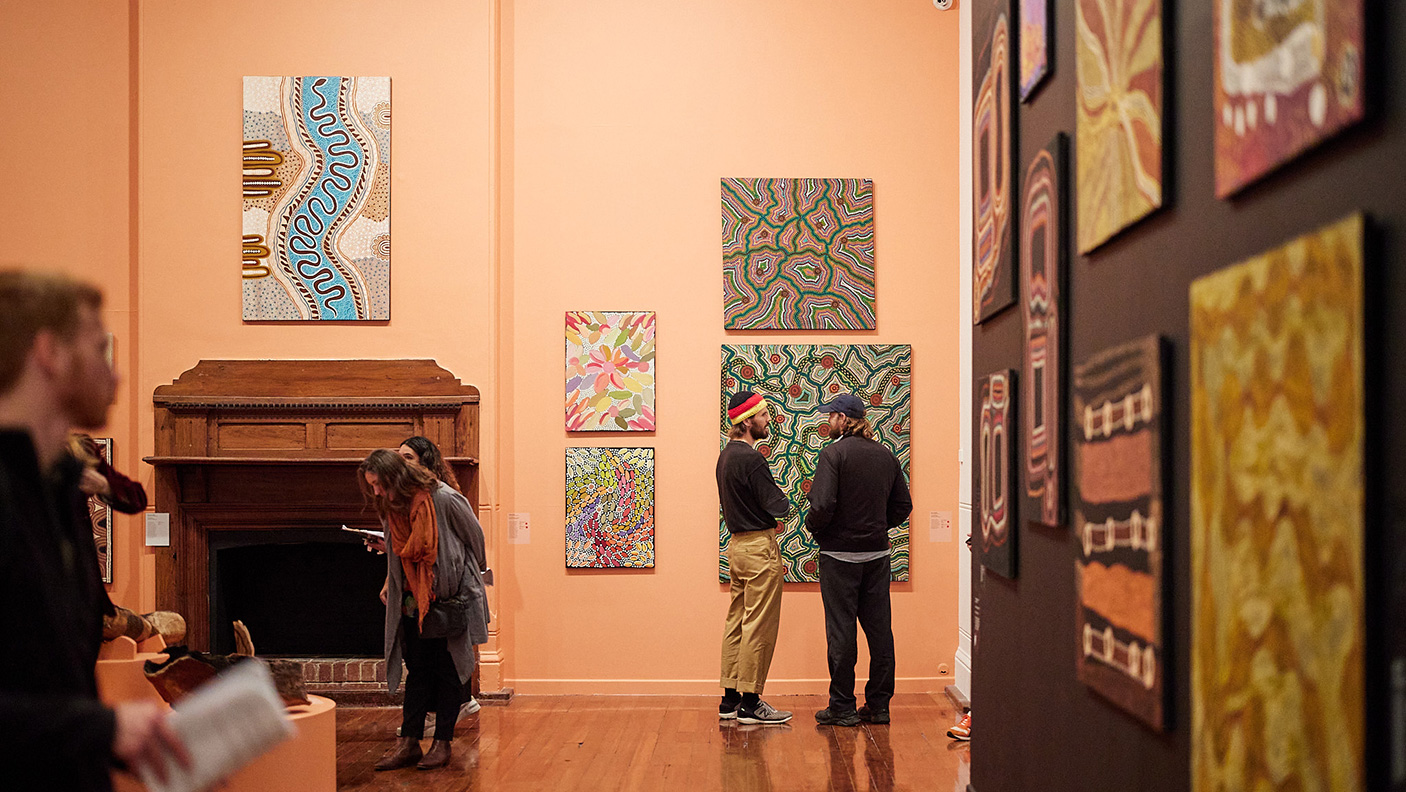People view an exhibition of Aboriginal art hanging in an art gallery
