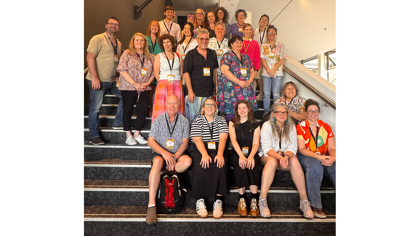 More than 20 delegates to the Australian Performing Arts Exchange, stand and sit on a staircase