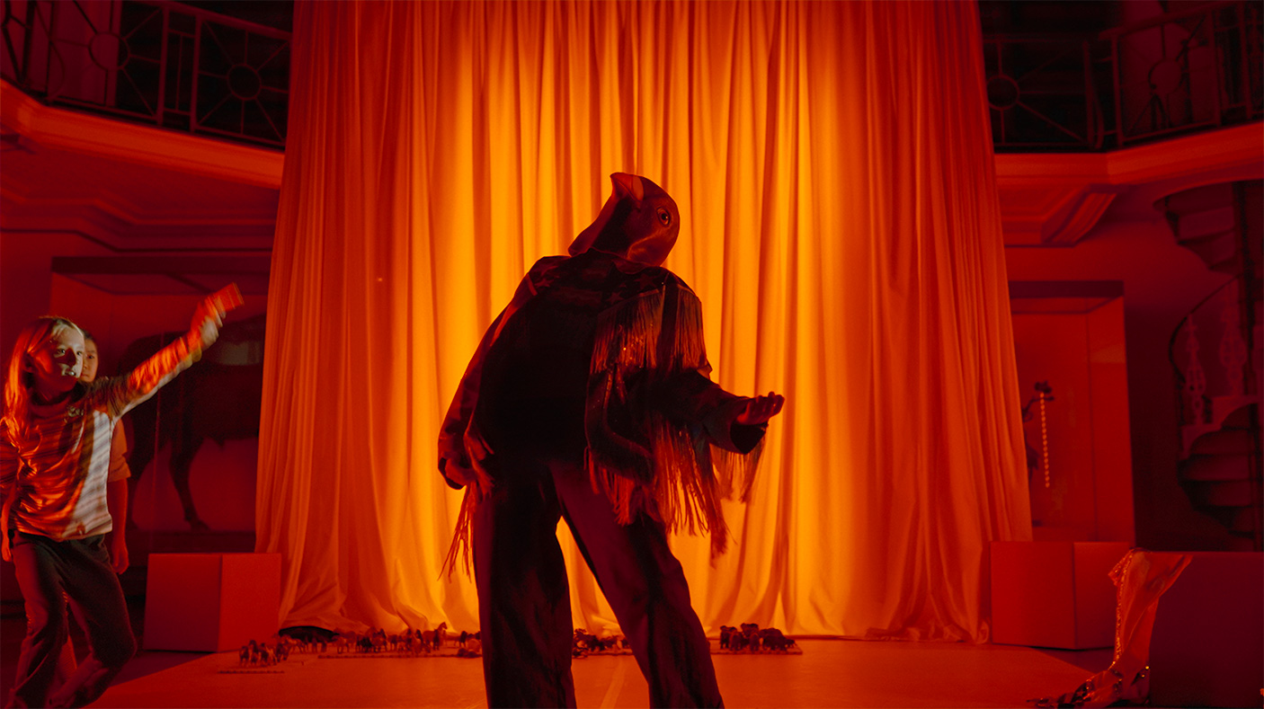 An actor in a bird costume on stage during a stage performance
