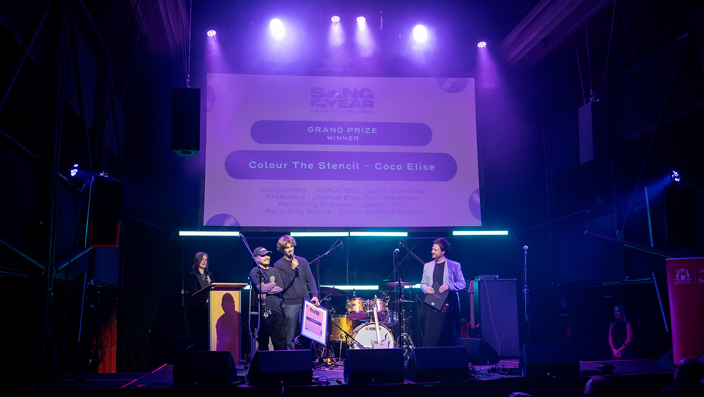 A band on stage accepting an award for Song of the Year