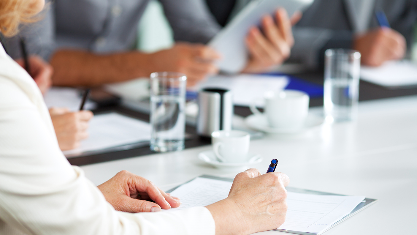 People having a meeting seated around a table with documents