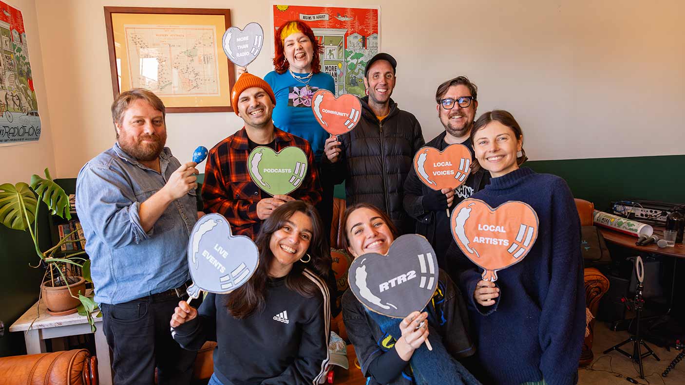 A group of people holding up heart-shaped posters promoting RTR-FM