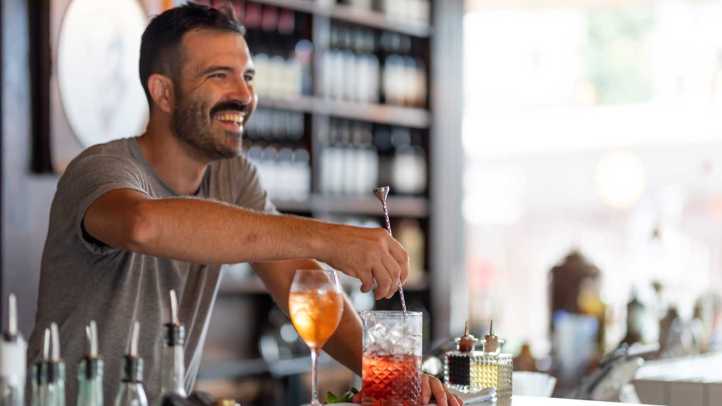 A bartender making drinks at a bar