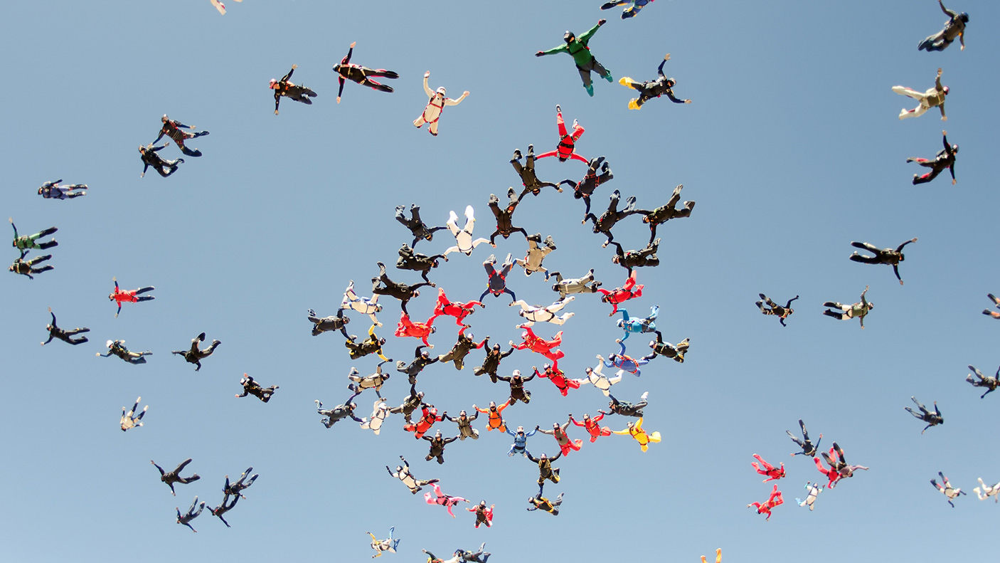 A large group of skydivers get into formation