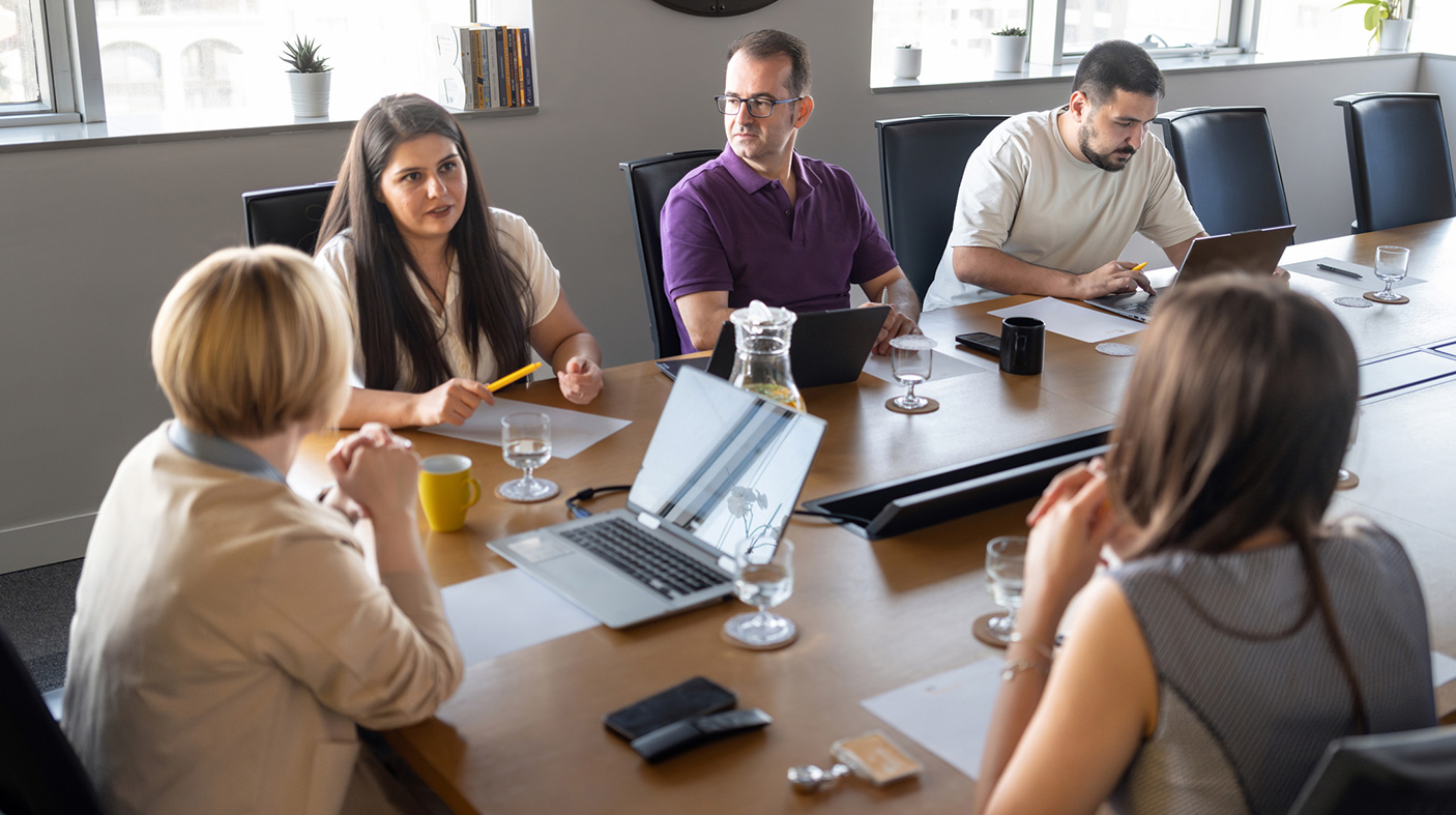 Stock image of people sitting around a board room table