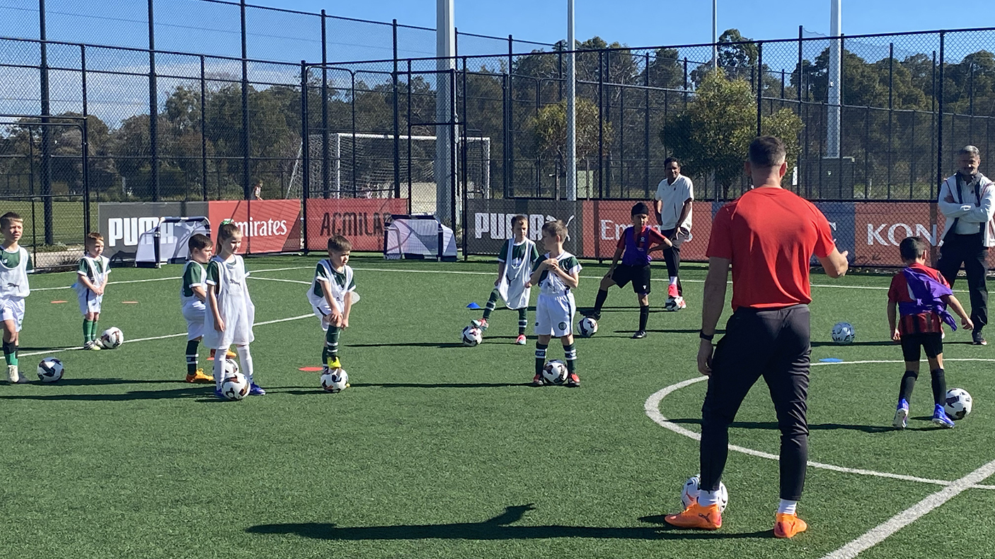 Junior socer plays on a field with Italian football players