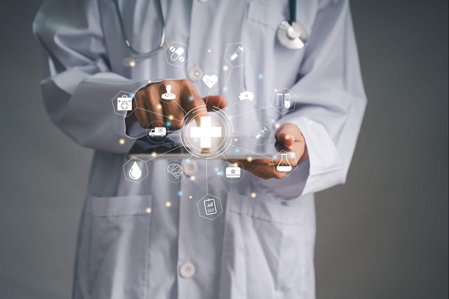 Doctor in white coat pointing at touch screen with medical icons displayed - Stock Photo
