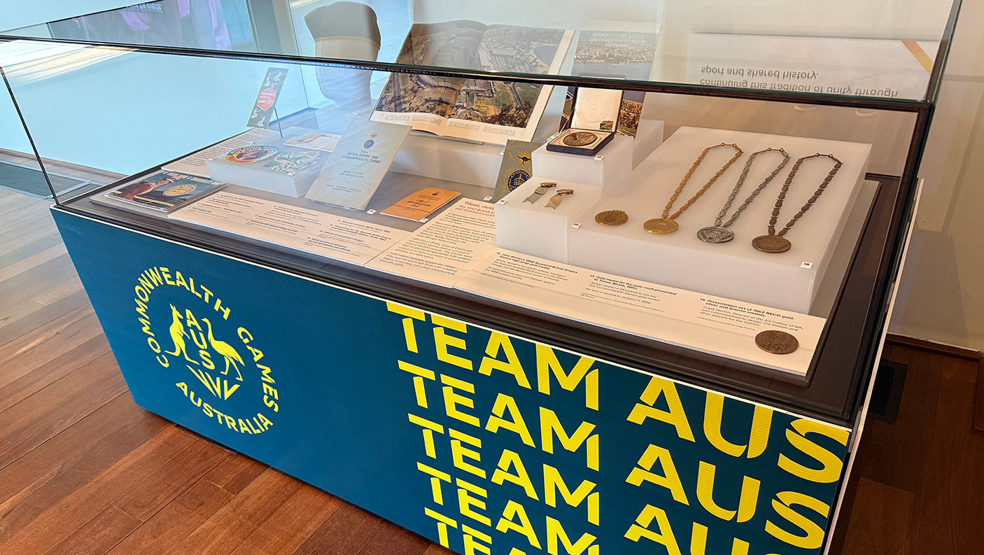 A museum display case with Commonwealth Games medals and other related historical documents