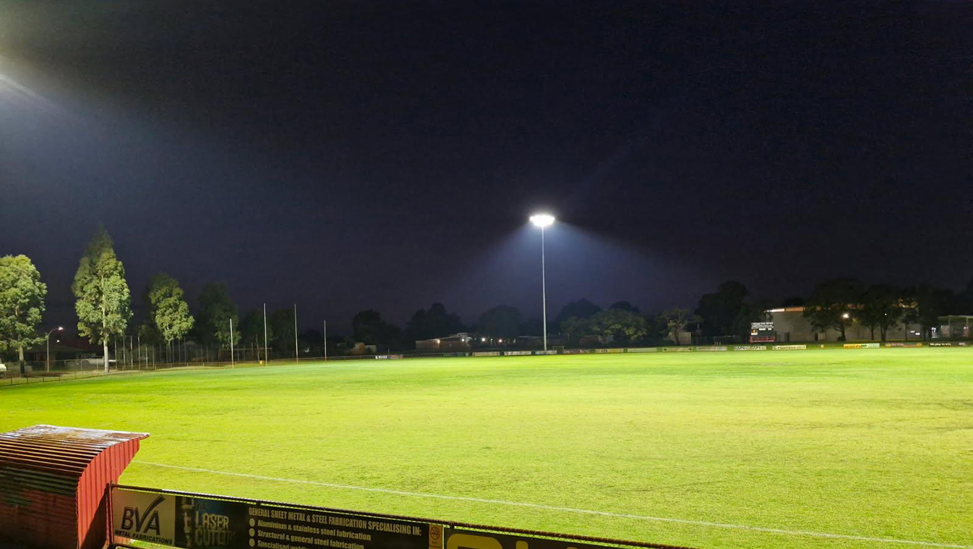 Flood lights lighting up the Glen Huon Reserve including the playing pitch and trees