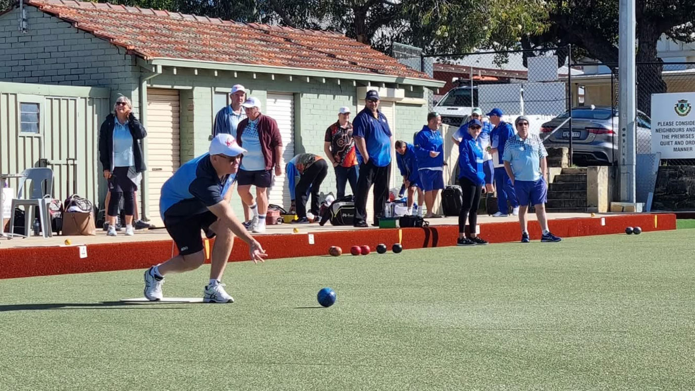 A group of people play lawn bowls at the North Perth Bowling Club