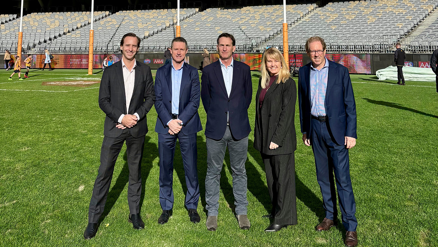 5 people in suits stand on a football oval