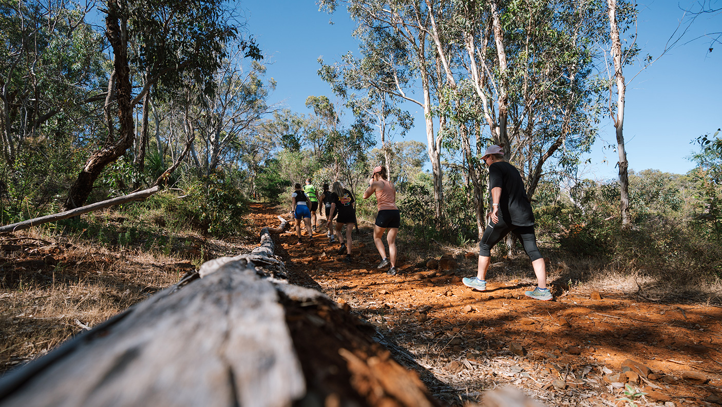 A small group of people on a bush walking track in the Perth hills.