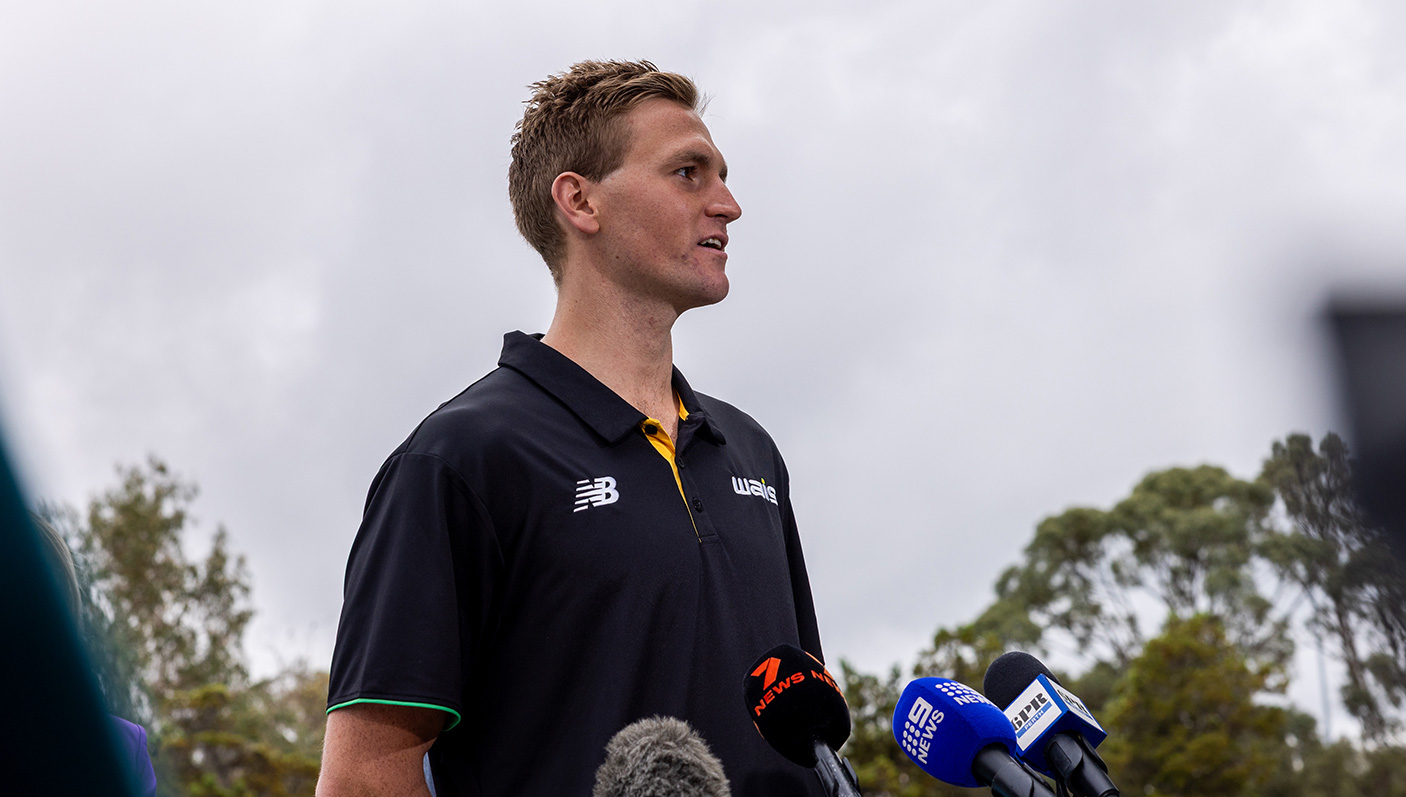 Olympic Endurance Swimmer, Kyle Lee stands in front of press microphone