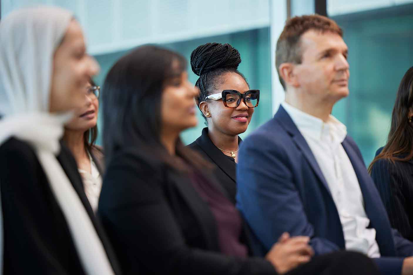A group of professional people standing together with the focus on a woman